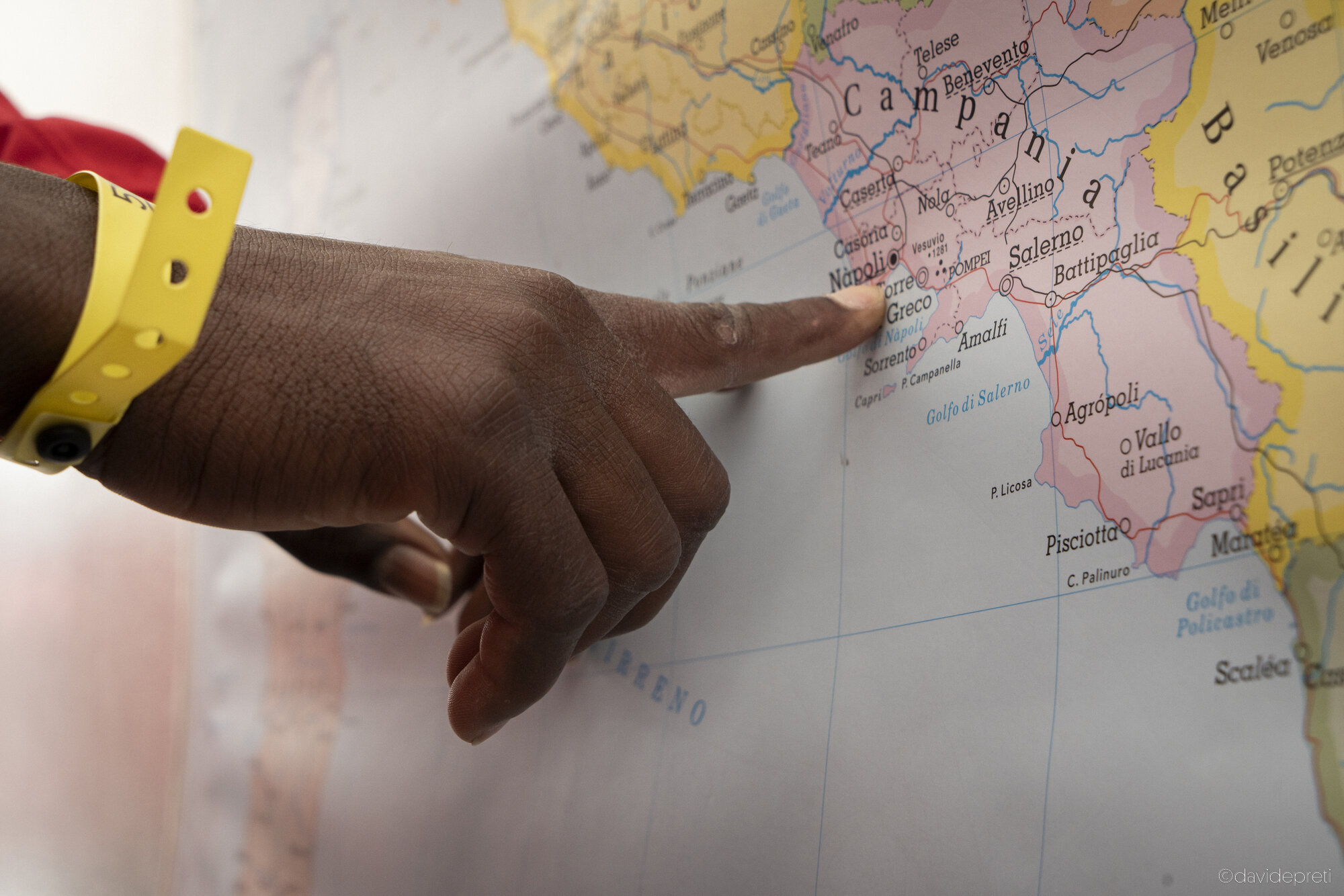 Central Mediterranean Sea — May 5, 2024.

A survivor points to Naples on a map of Italy located on the ship's covered deck.
