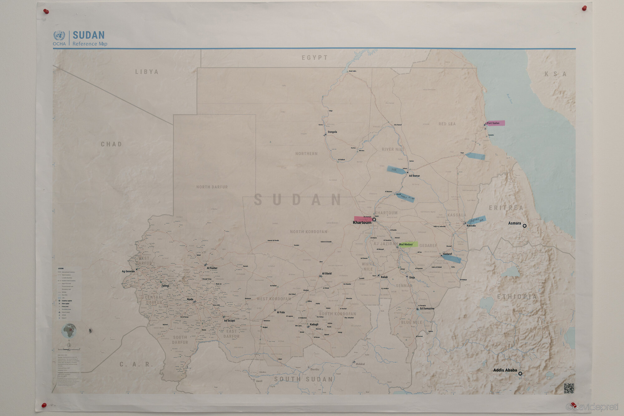 Khartoum, Sudan — November 25, 2025.

A United Nations OCHA reference map hangs on the wall of the logistics office at EMERGENCY's Salam Centre for Cardiac Surgery. The map outlines the operational network across a country divided by conflict between the Sudanese Armed Forces (SAF) and the Rapid Support Forces (RSF). While facilities in the central and eastern regions are coordinated from Khartoum, western outposts — including the hospital in Nyala and clinics across Darfur — remain isolated by frontlines and accessible only via cross-border humanitarian corridors from neighboring Chad.
