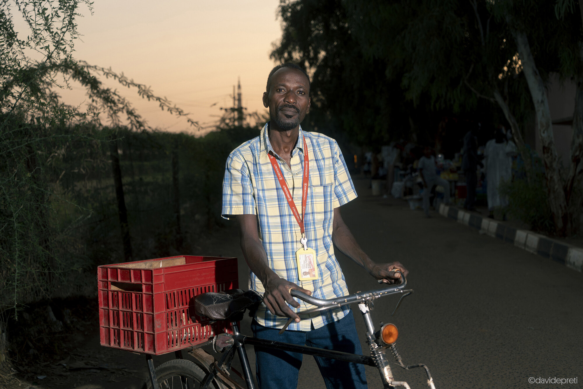 Khartoum, Sudan — November 23, 2025.

OUSMANE - 41 yo

He has never left EMERGENCY's Salam Centre in Khartoum in two years of war. Since 2015, he has been working as a logistician, managing supplies, transport, and staff. In early 2025, with the conflict encircling the hospital, he coordinated the movement of patients and staff to the basement during the shelling.

Today food is scarce and prices have skyrocketed; he often delivers essential goods by bicycle, navigating checkpoints and blockaded streets. "This hospital is the only one that has remained open since April 15, 2023," he says.

His youngest daughter, Fatima, was born during the war. The pregnancy was monitored at a neighborhood clinic, but for the birth, the family had to navigate treacherous roads and multiple checkpoints. After hours of travel and waiting, Fatima was born in the late afternoon. "Now I hope the war ends," he says, "and that children will stop playing at being soldiers."

