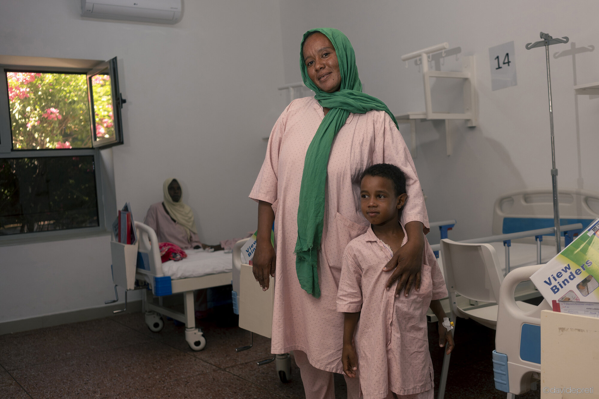 Khartoum, Sudan — November 18, 2025.

M. - 34 yo

She is a mother of seven and a cook at a Khartoum police station. Before April 15, 2023, hers was a happy family: the children attended school, and the older ones worked. The situation shifted in December 2024, when RSF paramilitaries killed her husband at the central market for resisting the theft of his daily earnings.

A few days ago, her youngest son, A., developed chest pains and a severe cough. "None of my children had ever been sick before the war," M. says from the pediatric ward of EMERGENCY's Salam Centre, where the boy is now receiving therapy.

Here, after more than two years of war, she is calm and safe. "If Khartoum does not return to what it once was, I will look for a safe place for my children," she says. "Even in Europe, if necessary."
