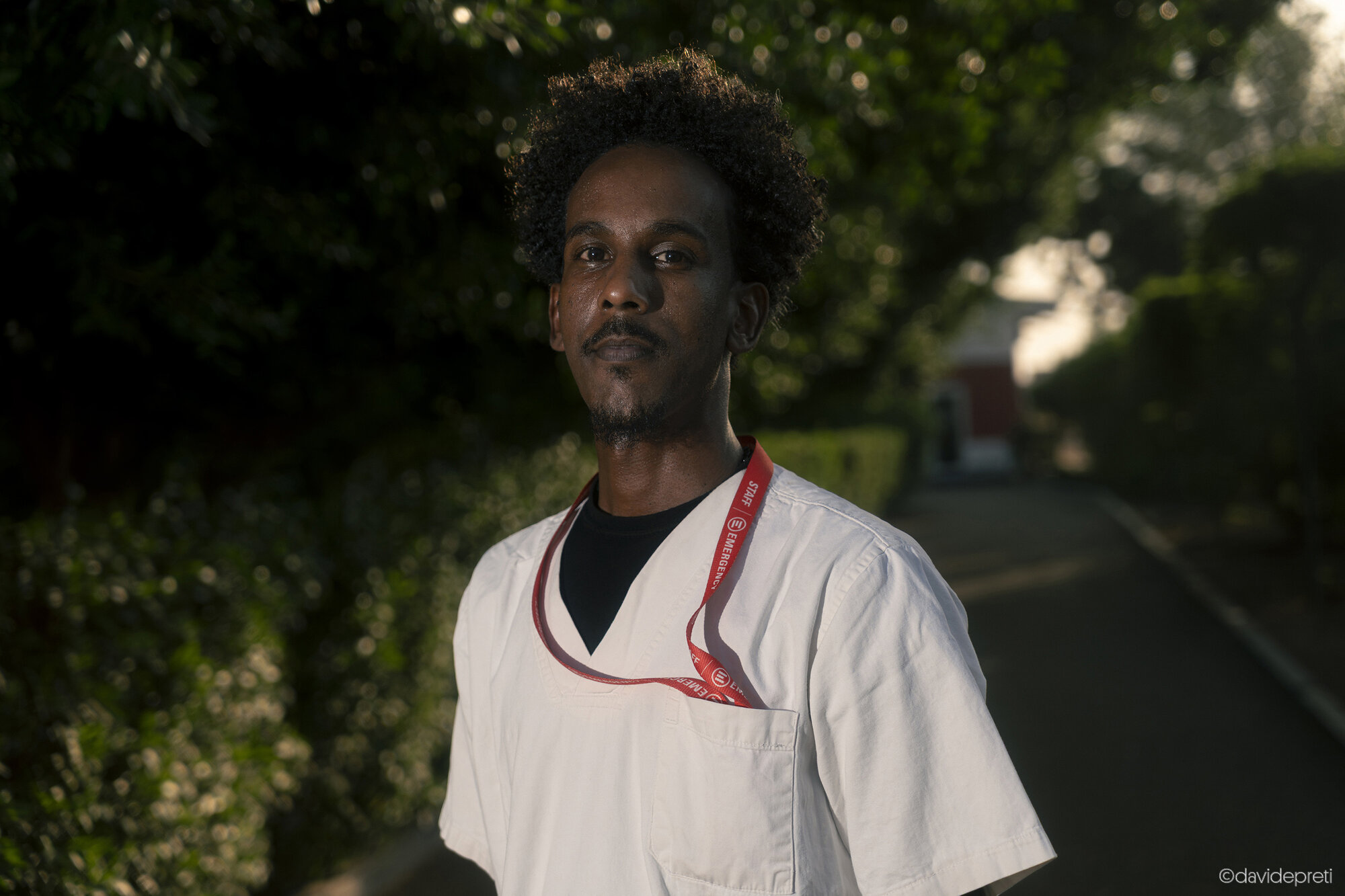 Khartoum, Sudan — November 23, 2025.

SAMIR - 33 yo

He is now a receptionist at EMERGENCY's Salam Centre. Before the war, he worked for an export company. The conflict forced his family to flee, but he chose to remain in Khartoum alone.

His decision is rooted in the "December Revolution" of 2018. Samir lived through every phase of the protests, from the first march to the permanent sit-in that led to the fall of dictator Omar al-Bashir in April 2019. "We were happy to be there together," he recalls. "In Sudan, we are divided on everything, but that time we were united for change." On June 3 of that year, he survived the "Khartoum Massacre," barricaded for eleven hours inside a hospital while security forces crushed the uprising. "We laid the dead out in rows, covered in white sheets, while outside they beat our friends and burned everything," he says.

Today, many accuse the activists of triggering the war by toppling the old regime. "They claim that if we had not protested," Samir says, "the conflict would never have started."
