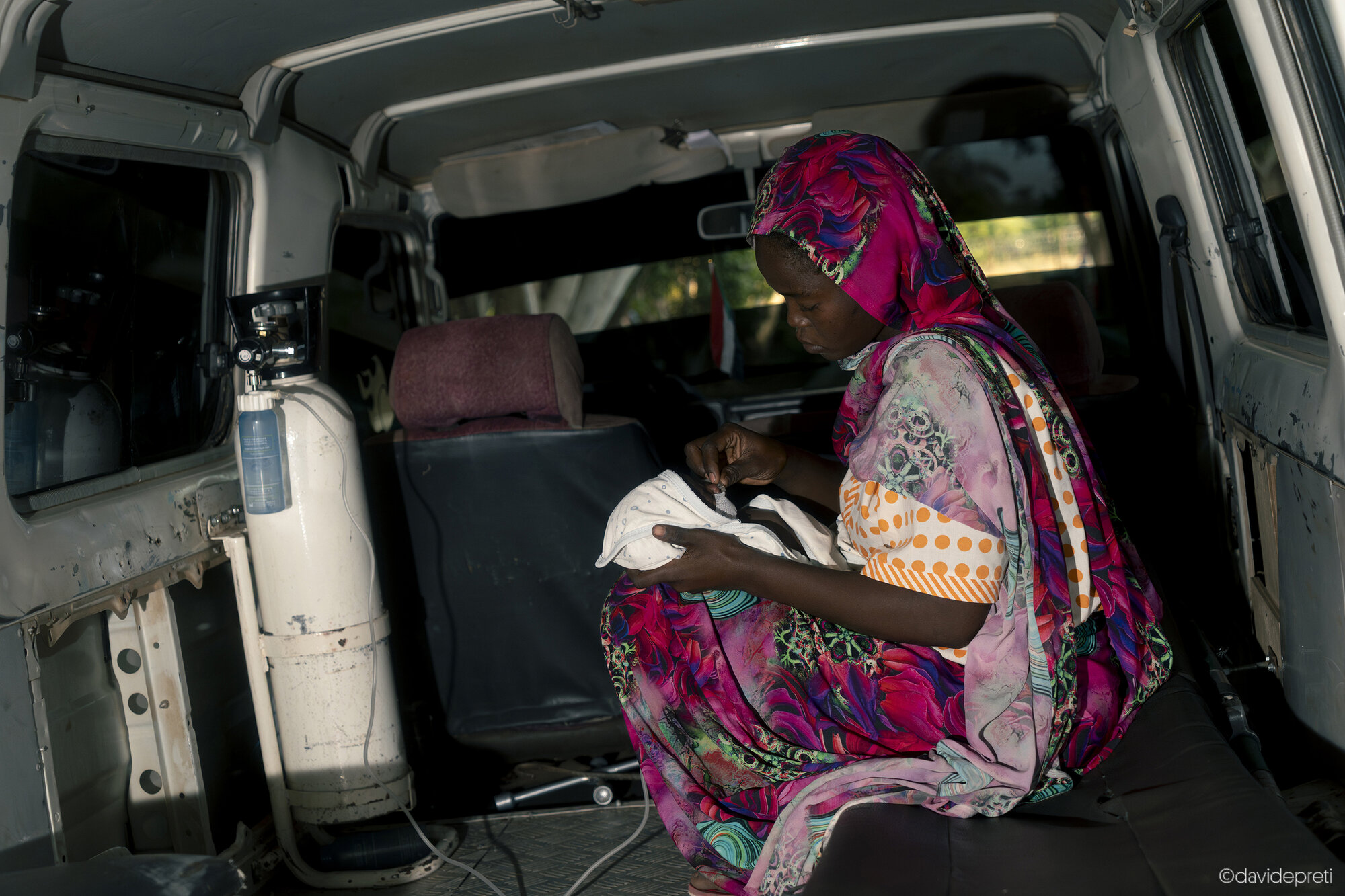 Khartoum, Sudan — November 20, 2025.

A mother tends to her newborn infant inside an ambulance during a transfer from EMERGENCY's Salam Centre for Cardiac Surgery to another healthcare facility in the capital. The infant was transferred to undergo specialized diagnostic tests unavailable at the center.
