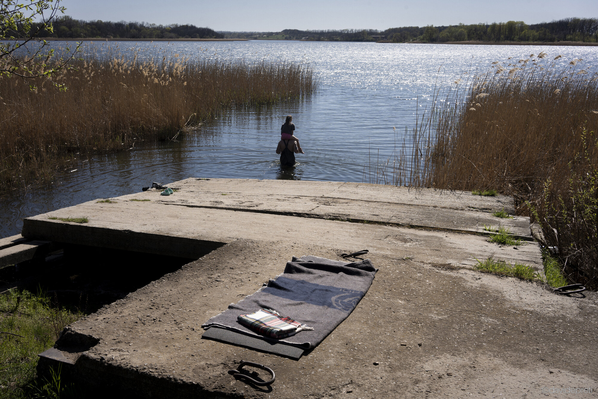 Lozova, Ukraine — April 19, 2025.

A father relaxing on the riverbank with his daughter.
