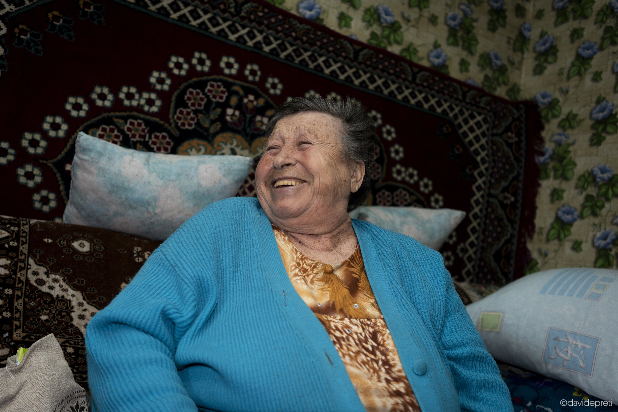 Maryevca, Ukraine — April 16, 2025.

ALINA - 80 yo

"When I was fifteen and a half, I went to Kostroma—which is even further than Moscow, near the Volga River—to study weaving at a vocational school. I graduated there and then went to university. During that time, I also took skydiving and precision shooting courses. I have a certificate and a special pin to prove it.

Once I finished university, I decided to go back home because I missed my parents. Initially, I went to Donetsk, where I found a job. But when Perestroika started, I lost my job, so I returned here to my village. At that time, my parents were sick, so I started working in a textile factory.

I never got married or had children. I'm single and childless. That's just how it went. Ever since my parents passed away, I've been living alone. I only have my sister, who lives nearby and is very old now.

I could kiss Olena every single day! She is such a huge help. The first time she knocked on my door, she came to get to know me and understand my situation. Then she came back again. She brought me medication and told me it was free. Tanya, the feldsher, told me I needed injections, so Olena and Zhenya (another feldsher) gave me a course of injections.

I always tell them: "Please, don't lock the door." I leave it unlocked so they can reach me easily. They know where everything is; they know where my things are. I am so grateful—they are always helping me. I needed medicine for my leg and a walker. As you can see, I can't walk. I also needed crutches and adult diapers. They brought me everything. We got along so well with them because they were from Donetsk too, just like me. That's why we feel so connected.

When people die, they die. I could say it differently, but it wouldn't change anything. That is the reality. Who wants all this? It's madness. There should have been a ceasefire long ago. Does he stop fighting? No, he keeps attacking. How many children have died? How many adults? How many civilians? How many people have been forced to flee? It's pure madness. It hurts, it makes you angry, it's heartbreaking. How can I describe it in just one word? It's tragic."
