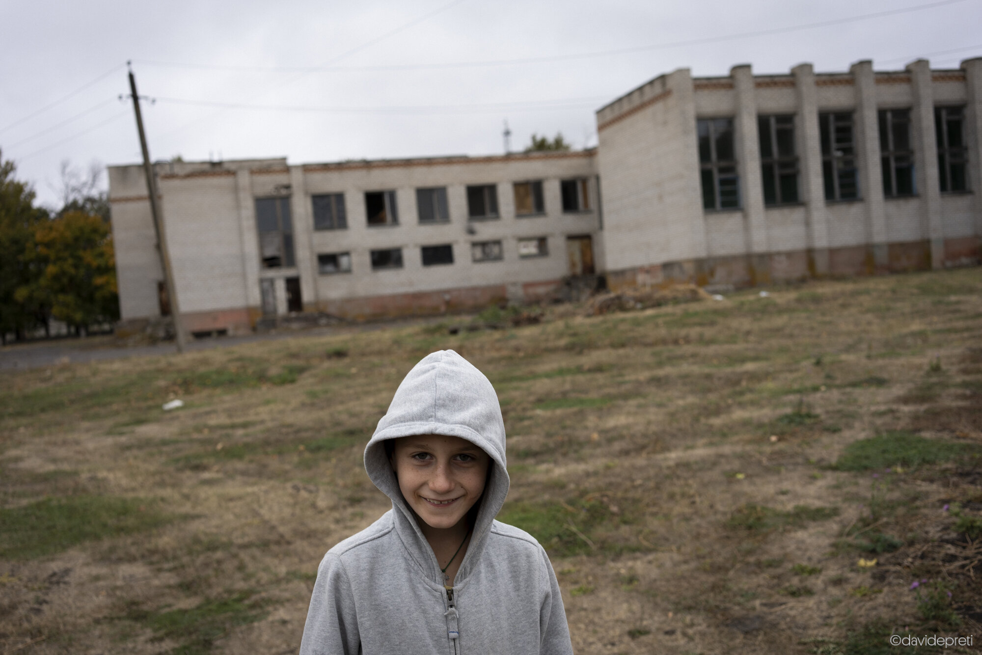 Mar'ivka, Ukraine — October 18, 2024.

A child standing outside his school, which was deemed unsafe following heavy bombardment.
